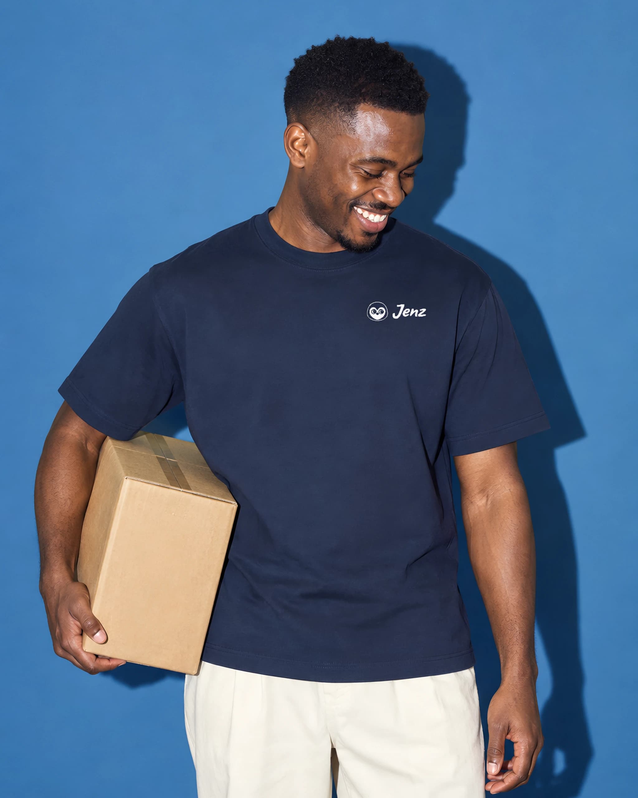 Man in a navy T-shirt with a small white Jenz logo on the left chest, a box under his arm
